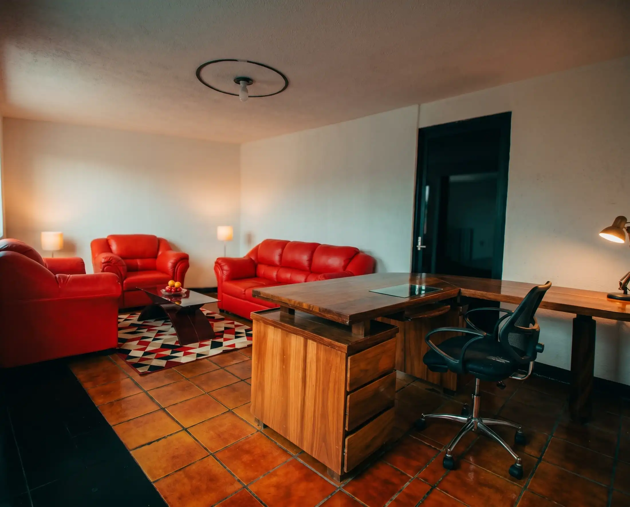 Consultorio de Rayito con sillones rojos y escritorio de madera
