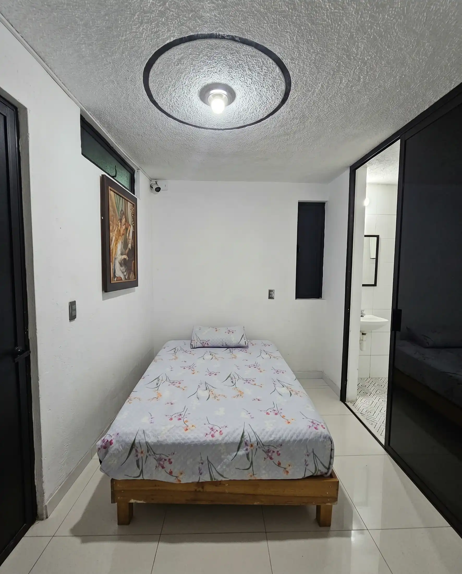 Habitación privada de Rayito con cama, baño privado y luz cálida