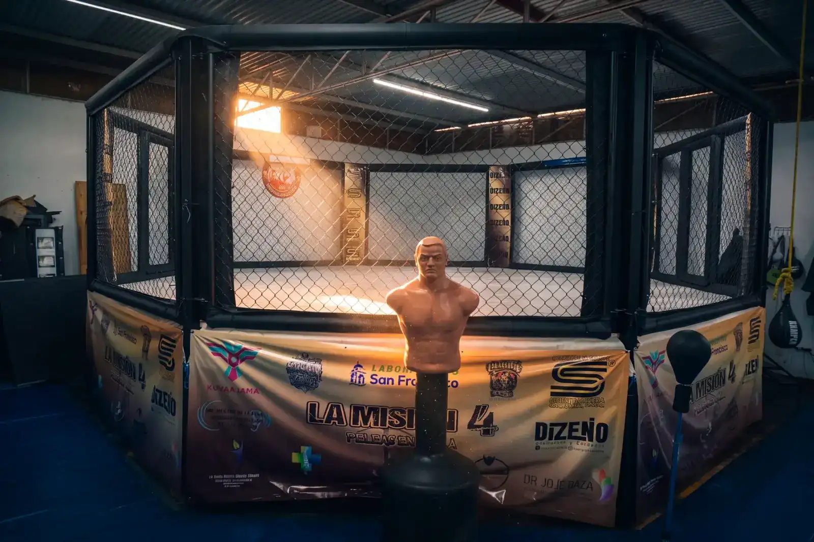 Octágono de entrenamiento de artes marciales mixtas iluminado por un rayo de sol